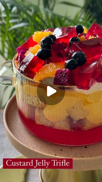 Sneha Singhi Upadhaya on Instagram: "Jelly Custard Trifle This trifle is the perfect dessert to make your friends/siblings/family feel special on any occasion. It comes together so easily & looks absolutely stunning. Let’s make it.   Wearing @prakritijaipur   Serves 6-8 1 packet jelly (I’ve used strawberry flavoured jelly) 500 mls hot water 1 tbsp agar agar Mix the jelly & agar agar well in your trifle bowl. Pour in the hot water & whisk till all the jelly crystals are dissolved. Transfer a little bit of the mixture in another dish (for garnish). Let this set in the fridge for 30-40 minutes or until the jelly is completely set.  Custard 6tbsp custard powder 1/4 cup sugar 300 ml milk Heat the milk, sugar & custard till it thickens whisking continuously to avoid burning. Keep aside & let it Jelly And Custard Desserts, Jelly Custard, Jelly And Custard Cups, Strawberry Agar Agar Jelly, Gulab Jamun Trifle, Fruit Trifle, Jelly Crystals, Trifle Bowl, Vanilla Sponge Cake