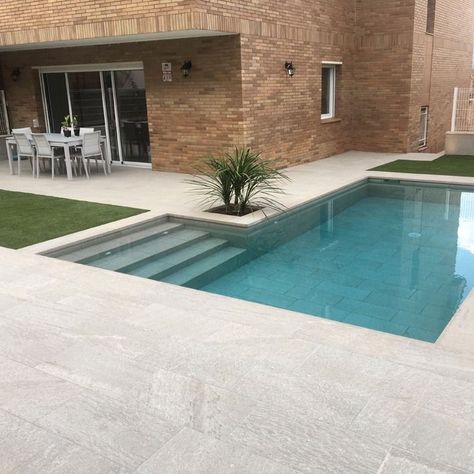 Grays go with everything! They're super stylish and turn the water a stunning turquoise blue. Just take a look at the picture. For this project, Piscinas AOP chose to cover the entire pool and patio with our Serena Griggio color. The pool measures 7 x 3 m and features an L-shaped design with built-in stairs. Congratulations! L Shape Swimming Pool Ideas, Trapezoid Pool, Small L Shaped Pool, L Shape Swimming Pool, Pool L Shape, L Shape Pool Ideas, L Shape Pool, Porcelain Steps, L Shaped Pool