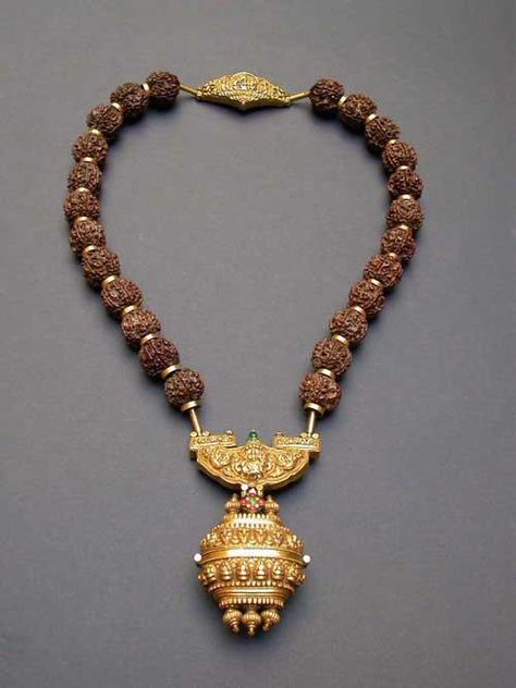 According to the seller this is a Govrishankaram - a necklace of rudraksha beads with a gold repoussé pendant and an amulet box suspended below.The Rudraksha beads are interspersed with gold rings and a repoussé gold worked pendant and clasp. Worn by a Shaivite priest only on a special ceremony. Rudraksha Necklace, Rudraksha Jewelry, Rudraksha Beads, Antique Jewelry Indian, Antique Gold Jewelry, India Jewelry, Ancient Jewelry, Tamil Nadu, Temple Jewellery