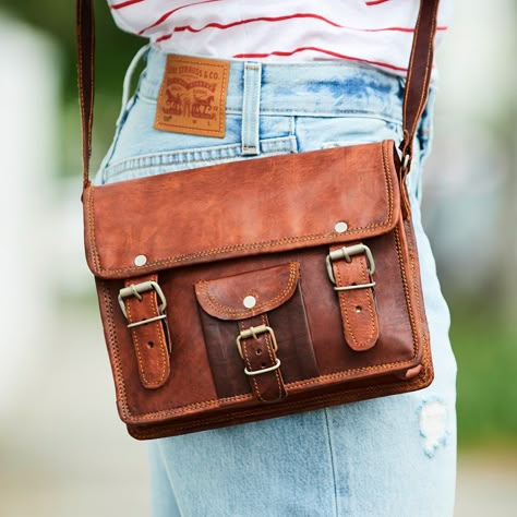 Lovingly designed and handmade with all the necessary vintage feel to ensure it’s the perfect everyday satchel. We use our signature ‘suntanned’ leather which works so well with this design. This leather will continue to develop a rich patina with use. It comfortably fits daily essentials. The shoulder strap is adjustable. Inside there is a dark green canvas lining and 2 zip pockets. With every sale we guarantee the provision of a school bag to a Cambodian child in need, through the awesome charity – United World Schools. We include details of how you’ve helped – a great addition if it’s a gift. It arrives in Vida Vida dustbag. Simply wipe clean with a damp cloth. Leather Workshop, Bag Inspiration, Leather Messenger Bag, Goat Leather, Leather Messenger, Satchel Bag, Classic Leather, Leather Satchel, Leather Handbag