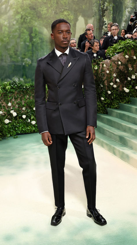 Prada Ambassador Damson Idris attending the 2024 Costume Institute Gala “The Garden of Time” at the Metropolitan Museum of Art.  Damson Idris wore a black wool double-breasted peak lapel tuxedo, charcoal grey poplin shirt with contrasting collar, and black silk tie, paired with lace up shoes.  #PradaPeople #DamsonIdris #MetGala Damson Idris Outfits, Damson Idris, Charcoal Black Suit, Double Breasted Suit Men, Black Men Fashion Urban, Classy Suits, Classy Outfits Men, Dress Suits For Men, Prom Suits