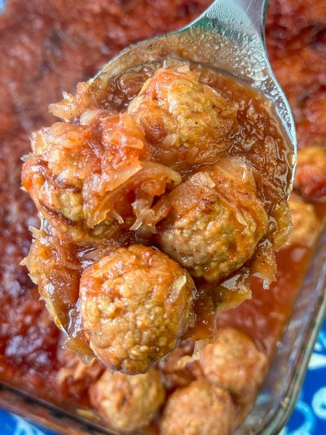 Serving spoon lifting delicious sauerkraut meatballs over top of the full baking dish. German Meatballs With Sauerkraut, Sauerkraut Meatballs Crock Pot, Saurkraut And Meatballs, Meatballs And Sauerkraut, Sauerkraut And Meatballs, Cranberry Sauerkraut Meatballs, Sauerkraut Dinner Recipes, Sourkrout Meal Ideas, Meatballs With Sauerkraut