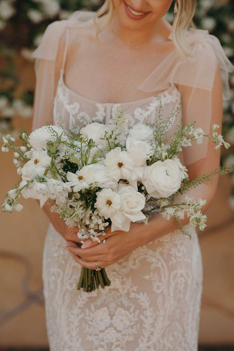 Elegant white modern bridal bouquet with roses, dahlias, and ranunculus, showcasing minimalist design and timeless beauty for a chic wedding day. Simple Bridal Party Bouquets, Minimal Bridal Bouquet White, Timeless Elegant Wedding Bouquet, Neutral Summer Wedding Flowers, White Poppies Bouquet, Simple Modern Bouquet, White Dahlia Wedding Bouquets, White Wild Flowers Wedding, White Boquetes Of Flowers Wedding