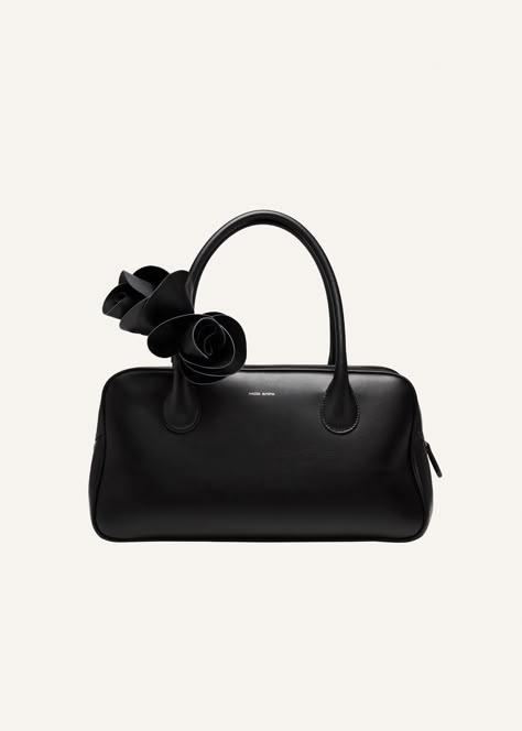 Introducing the Brigitte handbag. Inspired by the nostalgia of 90's while deeply rooted in Magda's family heritage. Its elegant silhouette, the roomy interior, two top handles and top zipper have been thoughtfully crafted in Italy. Adding a touch of on-brand dreaminess is the leather flower embellishment. Meticulously arranged and fixed onto the bag's handle. Leather Flower, 3d Rose, Magda Butrym, Family Heritage, Bowling Bags, Leather Flowers, Black Accessories, Clutch Pouch, Top Handle Bags