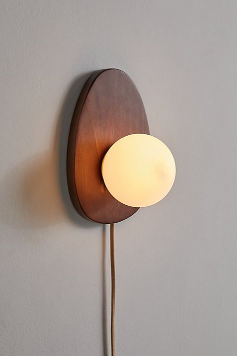 Refresh your lighting display with this statement sconce featuring a sculptural wood base topped with a milky glass shade. Plugs in to power on. Available exclusively at Urban Outfitters. Features Statement sconce from our Yoji lighting collection Sculptural base Milky glass shade Plug in UO exclusive Content + Care Wood, iron Wipe clean Imported Made in compliance with US electrical standards. To use this item outside of the US, pair with an outlet adapter and voltage converter made specifically for use in your location. Size Wattage/Voltage: AC 120V/60Hz Overall dimensions: 11.3" l x 7.4" w x 6.5" h | Yoji Sconce in Brown at Urban Outfitters Luminaria Diy, Plug In Pendant Light, Wall Lights Bedroom, Minimalist Lighting, Wall Sconces Bedroom, Sconces Bedroom, Organic Forms, Bedside Lighting, Wood Lamps