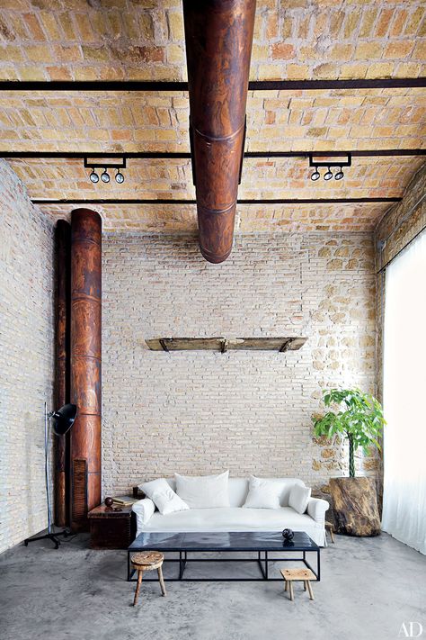 Pianists Katia and Marielle Labèque’s Rome apartment was decorated by Axel Vervoordt, a longtime friend. In the rehearsal room, a sofa and cocktail table—both Vervoordt designs—are joined by Montagnard stools. Brick Bathroom, Rome Apartment, Loft Interior, Loft Interiors, Industrial Interiors, Exposed Brick Walls, Brick Walls, Ideas Vintage, Industrial House