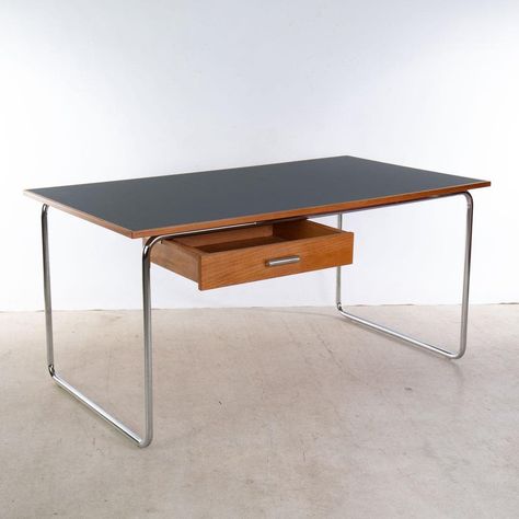 This exclusive Bauhaus-style desk, designed by Artur Drozd and produced by Design By Drozd, combines historical aesthetics with modern requirements. Proudly designed and manufactured in Berlin, this table represents the highest level of craftsmanship and first-class materials. The robust, chrome-plated steel tubes and the linoleum-coated table top guarantee durability and style. A drawer, either left or right, made of veneered beech offers practical storage space.  with dimensions of 150 cm x 80 Midcentury Modern Office, Funky Desks, Traditional Writing Desk, Desk Modern Design, Black Writing Desk, Bauhaus Furniture, Writing Desk Modern, Steel Desk, The Bauhaus