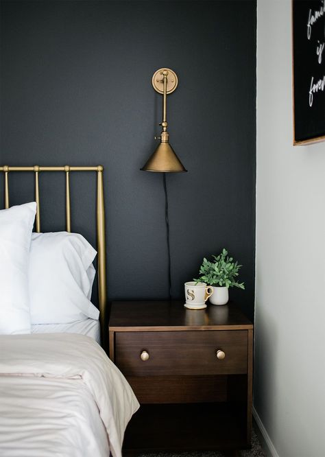 Have a black accent wall in your bedroom? Try pairing it with gold or brass accents, and walnut wood furniture. The paint color featured here is Blackish by Clare. Black Accent Wall Bedroom, Clare Paint, Brass Bedroom, Black Accent Wall, Black Walls Bedroom, Gold Sconces, Walnut Bedroom, Black Accent Walls, Bedroom Accent