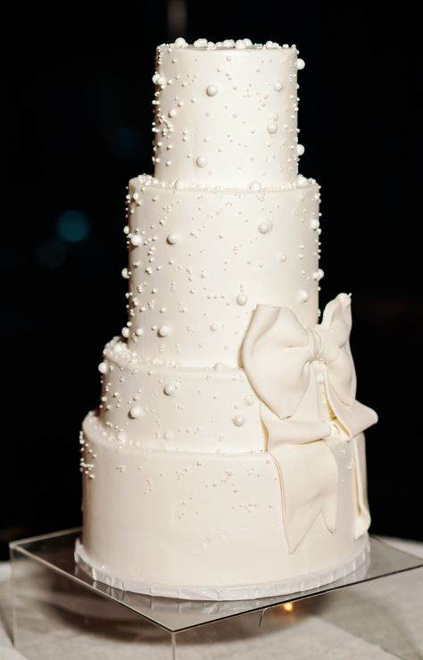 modern pearl and bow detail white wedding cake Wedding Cake Designs Pearls, White Wedding Cake With Bow, Pearl Cake Topper, Wedding Cakes With Bows, Black And Pearl Wedding, Bow Themed Wedding, Pearl Wedding Details, White Cake With Pearls, Cakesicles Wedding