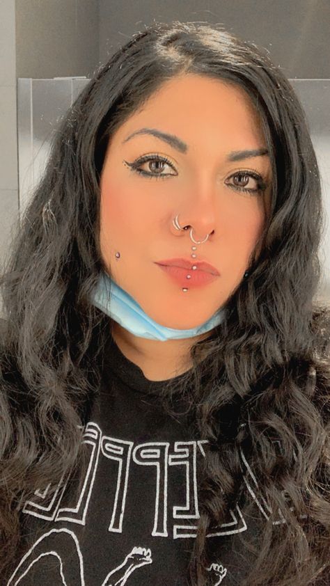 There are some facial piercings.  
girl:DeöVirgo Double Vertical Labret, Piercing Vertical Labret, Double Nostril, Double Nostril Piercing, Cheek Piercings, Double Nose Piercing, Vertical Labret, Nostril Piercing, Medusa Piercing