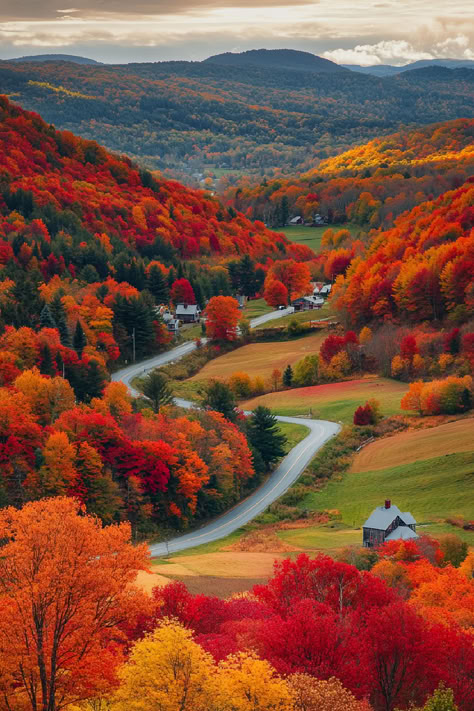 A scenic view of a winding road through a valley in New England, surrounded by vibrant fall foliage, one of the stops on the best fall foliage tours. Quaint houses dot the landscape, with rolling hills and forests in the background, creating a picturesque autumn scene. Fall In New England Aesthetic, Autumn In America, Fall In The Northeast, Connecticut Fall Foliage, Best Fall Foliage Usa, Fall Towns To Visit, Best Places To Go In The Fall, Fall Foliage New England, Halloween New England