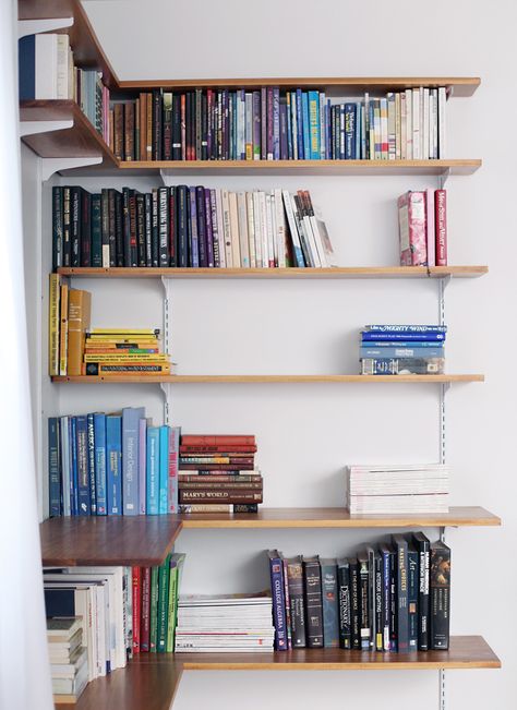 It's pretty simple to build your own shelving system. Click through for instructions and styling tips! Track Shelving, Bookshelf Corner, Corner Shelf Design, Corner Shelving, Long Living Room, Floating Bookshelves, Wall Mounted Bookshelves, Narrow Shelves, Office Shelving