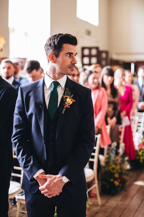 Groom in three piece navy blue suit and green tie turns his head as the bride starts walking down the aisle | Mike Plunkett Photography Blue Suit Green Bow Tie, Navy Blue Suit With Green Tie, Blue Suit Green Tie Wedding, Navy Suit With Green Tie, Navy Suit Green Tie, Traditional Groom Attire, Navy Blue Groom Suit, Navy Wedding Suit, Dinner Jacket Wedding