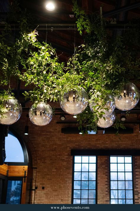 Retro meets elegance with this greenery hanging instillation featuring our fun and sparkly disco balls! To see more from our lighting inventory and weddings we've been part of, click the link in the pin and check out our website.   wedding lighting | wedding reception | elegant wedding | Minnesota wedding | wedding trends 2024 | wedding disco balls Greenery With Disco Balls, Greenery Wedding Reception, Wedding Reception Elegant, Athol Hall, Disco Ball Wedding, Wedding Trends 2024, Wedding Disco, Lighting Wedding, Hanging Clouds