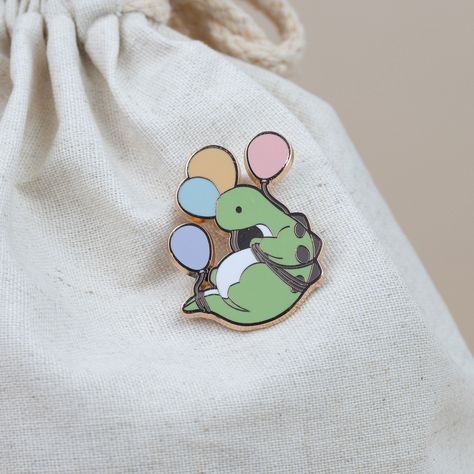 Looking for a fun, floaty companion? Bronti is always up for a good time and loves nothing more than a cheerful balloon ride. Show off this colorful pin today! Size: 1.6" x 1.8" Silly Drawings, Sketching Tips, Enamel Pin Collection, Cute Sewing Projects, Backpack Pins, Bag Pins, Diy Pins, Pin Art, Enamel Lapel Pin