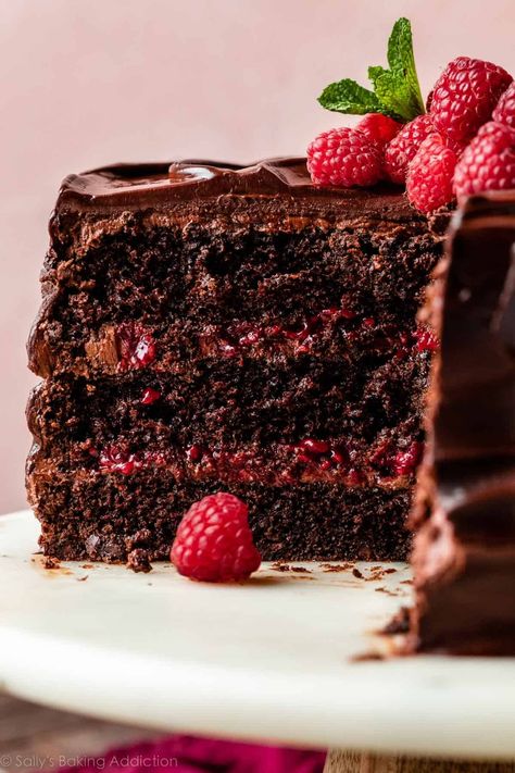 There's so much to love about this ultra-rich chocolate raspberry cake. Layers of moist dark chocolate sponge, silky chocolate buttercream, and homemade raspberry filling are enrobed in a luxurious chocolate raspberry ganache. This is a decadent dessert for anyone who loves the flavor combination of raspberries paired with deep, dark chocolate. Recipe on sallysbakingaddiction.com Raspberry Truffle Cake, Chocolate Raspberry Cake With Ganache, Rich Dark Chocolate Cake, Different Chocolate Cake Flavors, Raspberry Chocolate Torte, Raspberry Chocolate Lava Cake, Raspberry Chocolate Cake Recipe, Chocolate Raspberry Layer Cake, Chocolate Raspberry Cake Easy