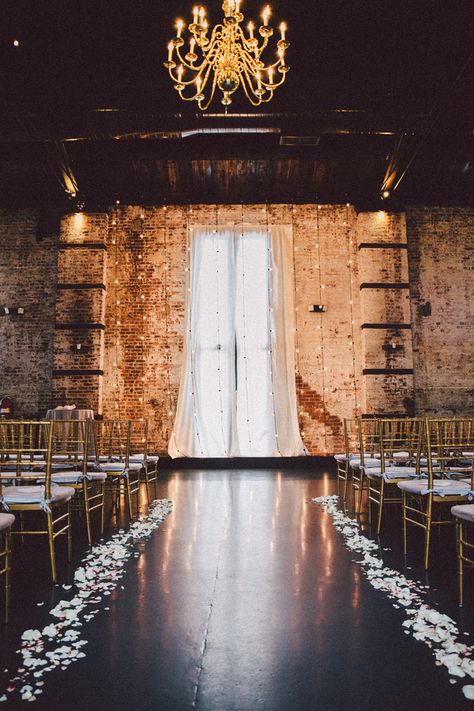 With tall brick walls and exposed beam ceilings, the ceremony and reception venue was the perfect location based on its beautiful interior alone. | Speakeasy Themed Industrial Wedding | Zorz Studios Loft Wedding Reception, Industrial Wedding Ceremony, Loft Wedding Ceremony, Industrial Wedding Decor, Urban Wedding Venue, Indoor Chandelier, Loft Wedding, Wedding Ceremony Backdrop, Urban Wedding