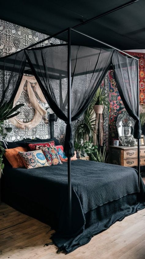 A captivating photo of a black boho-style bedroom, featuring a canopy bed with a sheer black canopy, adorned with a variety of colorful and eclectic cushions. The walls are adorned with a mix of intricate black and white wallpaper and colorful bohemian tapestries. The room also features a vintage-style wooden dresser, a decorative mirror, and an array of plants adding life and freshness to the space., photo Black Metal Canopy Bed With Curtains, Canopy Bed Couple, Goth Canopy Bed Ideas, Diy Canopy Bed For Adults Romantic Bedroom Ideas, Eclectic Cushions, Large Boho Bedroom, Black Boho Bedroom, Bedroom Design Boho, Black Boho Style