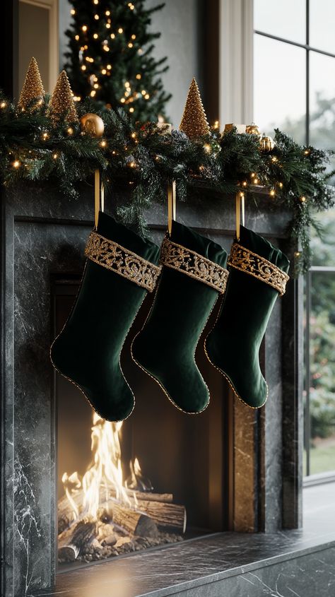 Three dark green velvet Christmas stockings with gold trim hang from a grey marble fireplace adorned with an evergreen Green Velvet Christmas Stocking, Velvet Christmas Stockings Ideas, Velvet Green Christmas Decor, Grey Marble Fireplace, Dark Green Christmas, Evergreen Garland, Gold Christmas Stockings, Trendy Christmas Decor, Classic Christmas Cards