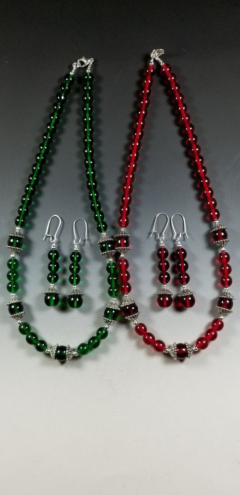 This pretty Necklace and Earrings set is available in your Choice of Emerald Green or Ruby Red.   The necklace is made with 8mm Translucent Czech Glass Beads highlighted with 10mm beads surrounded with Tibetan Silver Bead Caps. The overall length is 18 inches. It's strung on heavy duty tiger tail for strength and is finished off with a silver plated Lobster Claw clasp and Jump Ring. The matching earrings are 1-3/4 inches long ( not including the silver plated kidney shaped ear wires) and are lig Glass Stone Jewelry, Christmas Bead Necklace, Tiger Tail, Czech Glass Necklace, Genuine Pearl Necklace, Stone Bead Jewelry, Beads Craft Jewelry, Pretty Jewelry Necklaces, Heart Necklaces