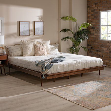 Accentuate your natural style with the Manor Park Mid Century Modern Wood Platform King Bed. This frame provides a perfect mix of style and function with the attractive tapered legs and wood support slats. The solid wood build offers a long-lasting piece to enjoy in your bedroom or guest room. Place it in a retro, modern, or boho style home for an elevated look. You can feel good about this purchase, as the wood is harvested responsibly from renewable forests. Pair with your favorite king headbo Floor Beds For Adults, Philly Apartment, Platform King Bed, Dark Wood Bedroom Furniture, Boho Bedrooms, Wood Platform Bed Frame, Modern Bed Frame, Mid Century Modern Wood, Wood Bedroom Furniture