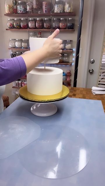 The Cake by Mildred, Orlando on Instagram: "When stacking cakes, the strength and size of your supports will depend on the size and weight of you cake. Here I used a central dowel nailed to the plate. The bottom tier has 4 wooden sticks distributed around the cake; to do this i used a 6” paper circle (which is the size of the top tier) to mark where I wanted my supports. I aligned the center of the circle with the large dowel and marked the cake. I measured the cake and cut the small wooden stic Stacking Cakes, Cake Dowels, Circle Cake, How To Stack Cakes, 8 Inch Cake, Paper Circle, 2 Tier Cake, Cake Central, Cake Cover