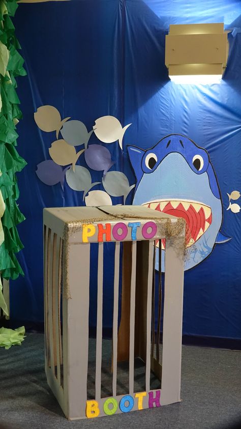 Photo booth-shark cage w/Bruce made by my partner in decorating, Kelcey.  Bruce hung by filament from light fixture then stabilized w/tape onto plastic table cover. Shark Photo Booth Diy, Diy Shark Party Decorations, Shark Centerpiece Ideas, Party Kids Table, Shark Decorations, Shark Week Party, Shark Cage, Shark Themed Party, Shark Themed Birthday Party