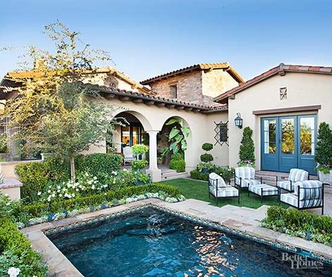 Instead of making the pool a backyard focal point, these homeowners downplayed its presence so the landscape suited their French-inspired home. Mediterranean-style plantings envelop the pool in pleasing colors, leafy textures, and clipped forms. Only a short span of bluestone provides entrance into the pool; the stone is a continuation of a small patio that partners with lush lawn to accommodate poolside seating. Spanish Pool, Mediterranean Backyard, Mediterranean Pool, Spanish Style Home, Backyard Pool Landscaping, Spanish Style Homes, Casa Exterior, Beautiful Pools, Backyard Pool Designs