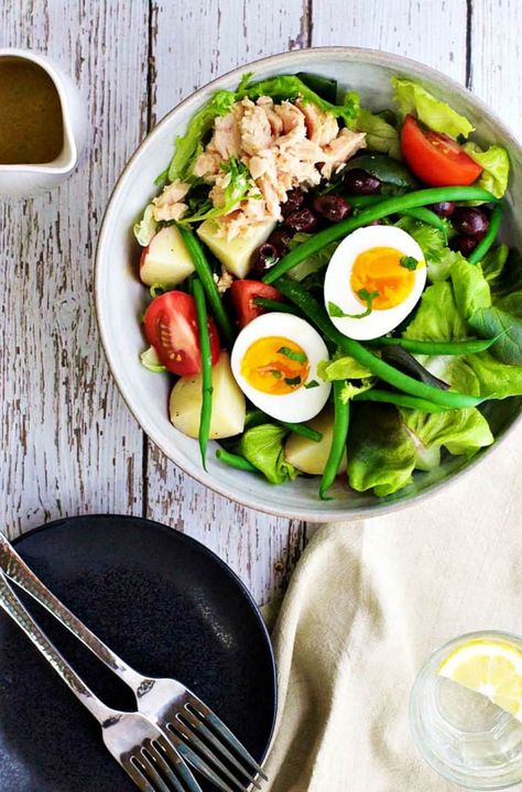 With a simple dressing and all of the classic ingredients (green beans, new potatoes, hardboiled eggs, olives and tuna) Nicoise salad is an easy, healthy recipe to make any time of year! Arrange each ingredient in a bowl and drizzle with dressing for a beautifully composed presentation. #nicoisesalad #saladnicoise #frenchfood #frenchbistro #tuna #summersalad #frenchcuisine Tuna On Salad, Bean Tuna Salad, Spring Dinners, Asparagus Pizza, Nicoise Salad Recipe, Tuna Nicoise Salad, Italian Chopped Salad, 5 Ingredient Dinners, Nicoise Salad