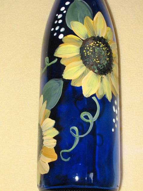 Hand painted, recycled cobalt blue wine bottle with sunflower design and finished with bottle stopper Can be used for oil, wine, dish detergent or just as a decorative piece for your kitchen and home décor. Cheerful yellow sunflower design is hand painted and then baked for a lasting finish. Many other colored bottles and floral designs are available, custom order. Approximate sixe is 13 1/2 inch height with stopper and 3 inch bottom diameter, wine bottles vary slightly. hand wash Painting Wine Bottles, Bottle Paintings, Christmas Bottles, Bottle Art Projects, Reuse Wine Bottles, Gourd Birdhouses, Colored Bottles, Wine Bottle Crafts Christmas, Blue Wine Bottles