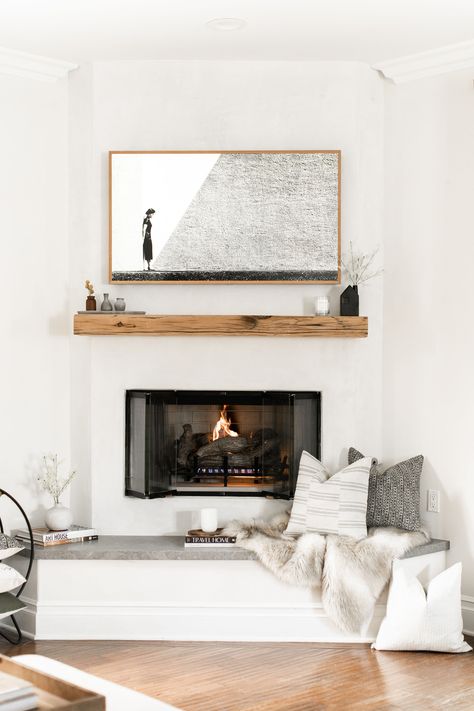 The coziest spot to enjoy a cup of coffee.  Even fireplaces love pillows! Photo by Public311 Design for Elsie Home.  #fireplacestyling #fireplacehearth #plasterfireplace #floatingmantel #livingroomstyling #familyroomstyling #designerpillows #designertextiles #throwpillows #decorativepillows #cozycorner #californiacasual #interiordesign Plaster Fireplace, Fireplace Styling, Reclaimed Wood Mantel, Fireplace Seating, Floating Mantel, Brick Fireplace Makeover, White Fireplace, Fireplace Hearth, Corner Fireplace