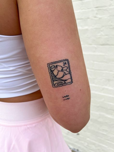 she has a tattoo of a stamp with mountains in the tattoo. under that tattoo is a small aquarius tattoo. black ink tattoos Stamp Tattoo Mountains, Switzerland Tattoo Ideas, Mountain Stamp Tattoo, Small Stamp Tattoo, Small Family Tattoo, Australia Tattoo Ideas, Austria Tattoo, Aus Tattoo, Switzerland Tattoo