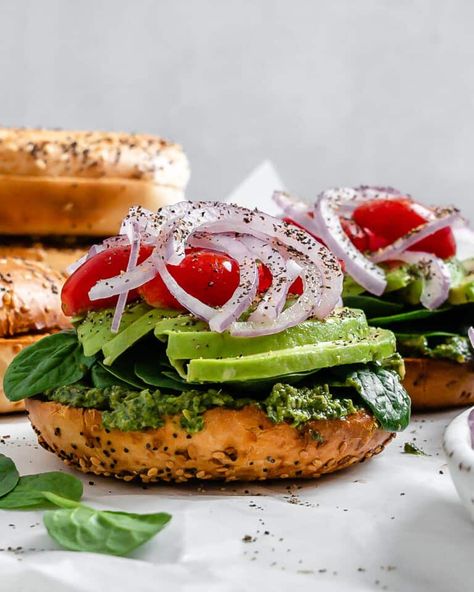 This Vegan Bagel Sandwich with Pesto is so easy to make and so flavorful! It's packed with a delicious Sun Flower Seed Pesto, veggies, and your favorite bagel to make the ultimate sandwich! #plantbasedonabudget #pesto #bagel #sandwich Vegan Bagel Sandwich, Pesto Bagel, Pesto Veggies, Bagel Fillings, Sandwich With Pesto, Bagel Sandwich Recipes, Ultimate Sandwich, Vegan Bagel, Bagel Breakfast Sandwich