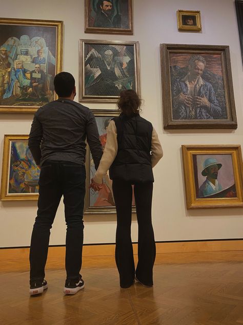 Two people standing together in front of a wall of museum art pieces, holding hands, dark aesthetic Couple Art Gallery Date Aesthetic, Couple At Art Gallery, Museum Date Aesthetic Couple, Art Gallery Couple Aesthetic, Museum Dates Aesthetic, Art Museum Date Aesthetic, Artist Couple Aesthetic, Museum Couple Photos, Art Gallery Date Aesthetic