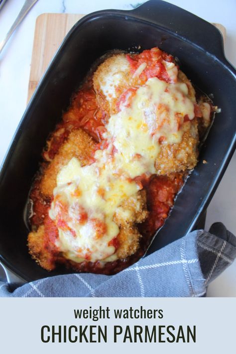 Black cast iron pan with two breaded pan fried chicken breasts topped with melted cheese, sitting on a bed of tomato sauce. A blue checkered napkin, wood cutting board and marble counter make up the background. The text stripe at the bottom reads "Weight Watchers Chicken Parmesan" Ww Recipes With Points 2023 Chicken, Low Cal Italian Recipes, Ww Chicken Parmesan, Ww Chicken Parmesan Recipe, Chicken Ww Recipes, Weight Watcher Chicken Recipes, Weight Watchers Chicken Parmesan Recipe, Weight Watchers Chicken Parmesan, Easy Weight Watchers Recipes