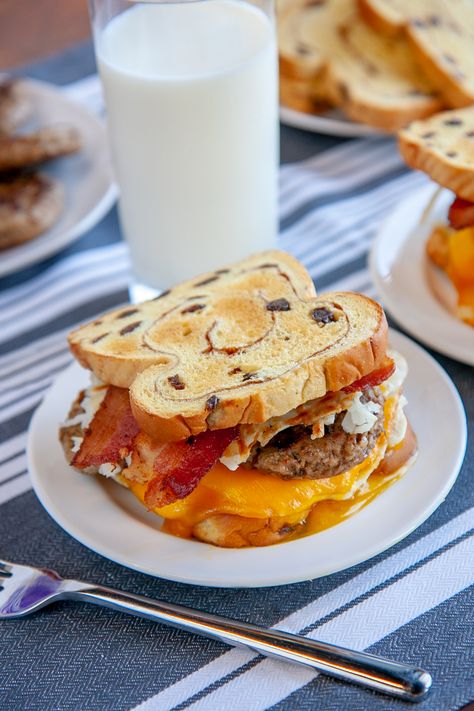 Cinnamon-Raisin Loaded Breakfast Sandwich | This action-packed sandwich combines sweet and savory flavors in perfect unison with bacon, sausage, hashbrowns, a fried egg, and cheddar cheese, between toasted slices of Cinnamon-Raisin Swirl. A breakfast masterpiece like this is sure to start your day off right. Sweet And Savory Breakfast Sandwich, Cinnamon Raisin Bagel, Bagel Breakfast Sandwich, Potato Rolls, Packed Breakfast, Breakfast Sandwich Recipes, Cinnamon Swirl Bread, Burger Night, Breakfast Bagel