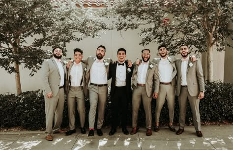 Groom wore a black tux with a black bow tie while his groomsmen wore a crisp tan suit and blush bow ties to match the gals Photo | Chuy Photo Planner | knotsandbelles Black Groom Tan Groomsmen, Tan Groomsmen Suits Black Groom, Black And Khaki Groomsmen, Khaki And Black Groomsmen Attire, Black Tux Groom Tan Suit Groomsmen, Black And Tan Groomsmen, Mismatched Groom And Groomsmen, Black And Tan Groomsmen Attire, Tan And Black Groomsmen Suits