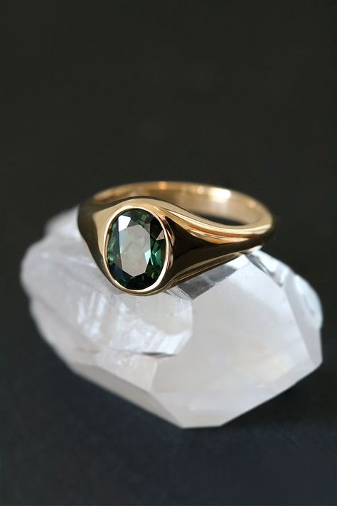 Exude timeless elegance with this unique signet ring. A vibrant 1.95ct Australian sapphire, boasting a deep forest green hue, is showcased in a gleaming 18ct yellow gold setting. Perfect as a statement piece or an alternative engagement ring, its warm tones and luxurious details make it a cherished heirloom. Currently an Australian size M, this one-of-a-kind ring can be resized. Gemstone Rings Men, Sapphire Signet Ring, Mens Gold Signet Rings, Stone Ring Design, Mens Ring Designs, Couple Ring Design, Australian Sapphire, Custom Made Engagement Rings, Deep Forest Green