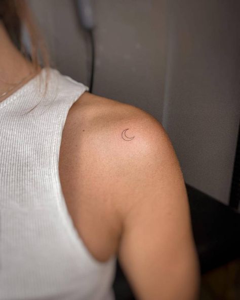 Tiny crescent moon tattoo located on the shoulder. Small Moon Neck Tattoo, Crescent Moon Tattoo Back Of Neck, Half Moon Shoulder Tattoo, Moon Tattoo On Shoulder For Women, Mini Tattoos On Shoulder, Minimalistic Shoulder Tattoos For Women, Crescent Moon Back Tattoo, Crescent Moon Tattoo On Shoulder, Moon Tattoo On Back Shoulder