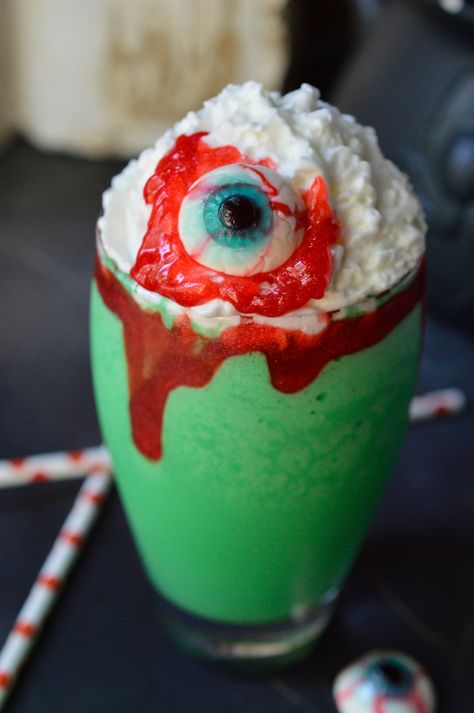 Make this Eye of Toad Halloween Milkshake Recipe for all of your creepy little monsters! This Halloween dessert is made with cookies and cream ice cream, green coloring, whipped cream, red blood gel and topped with a gummy eyeball. This fun recipe is kid approved! Spooky Spoon, Wonky Wonderful, Goth Ihop, Pumpkin Cookies Decorated, Halloween Cooking, Halloween Punch Recipes, Halloween Ice Cream, Halloween Cookie Recipes, Halloween Punch