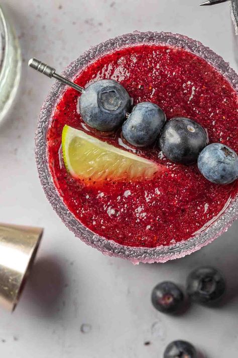 This blueberry margarita is a sweet frozen cocktail with a smooth and icy texture. Frozen blueberries lend a vibrant purple hue and a burst of fruity sweetness flavor to the classic margarita. Garnished with a lime wedges and fresh blueberries, you will love these easy-to-make frozen blueberry margaritas this summer. Brandy Slush, Tequila And Lemonade, Tequila Based Cocktails, Frozen Watermelon Margarita, Blueberry Margarita, Blackberry Margarita, Frozen Cocktail, Margarita On The Rocks, Pineapple Margarita