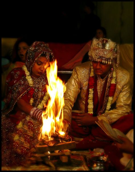 Traditional Hindu wedding ceremonies can last for days and involve many rituals in Sanskrit which are mostly understood only by the priest conducting the service. Hindu weddings are supposed to take place outside, on the earth, under a canopy known as a mandap. Front and center under the mandap is the sacred fire. Hindus consider the wedding fire, like other fires, to be a manifestation of Agni-the fire God. Among many sub-ceremonies during wedding..... One of the most important ritual is of... Indian Wedding Rituals, Hindu Weddings, Fire God, Sacred Fire, Holi Photo, Hindu Wedding Ceremony, Story Wedding, Wedding Ceremony Backdrop, Wedding Rituals