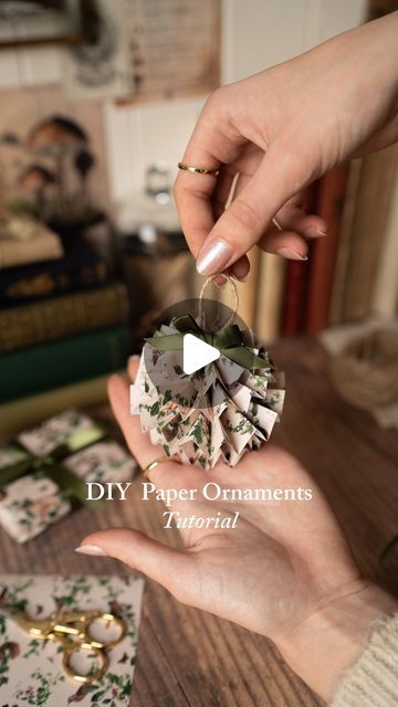 Fable England on Instagram: "DIY Paper Ornaments We’re feeling super crafty this festive season so we are opting to DIY a lot of decor. Here’s how we made these adorable paper ornaments. This is a lovely way to use up pretty wrapping paper you have saved!   What you’ll need: •patterned paper (we used our gift wrap!) •scissors  •tape •glue gun/hot glue •twine  •ribbon •ruler   Instructions:  1. Cut strips as follows:  • 2 strips 2.5cm by 30cm  • 2 strips 3cm by 40cm  • 1 strip 3.5cm by 50cm  (please note if your paper is not long enough you can tape the pieces together as shown in our video) 2. Fold each strip like an accordion about 1cm per fold 3. Use a hot glue gun to glue the ends of each strip together  4. Bend the circle strip inward to form a medallion and add a small drop of hot glu Kraft Paper Ornaments, Paper Accordion Ornaments, Twisted Paper Ribbon Crafts, Wrapping Paper Ornaments Diy, Paper Strip Ornaments, Twine Ornaments Diy, Diy Paper Ornaments, Glue Ornaments, Paper Ribbon Crafts