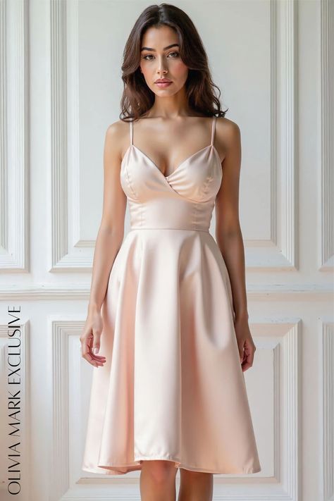 The dress, a symphony of satin and grace, cascades in a soft blush that speaks of dawn's early light. Its V-neckline, a whisper of allure, draws the eye upward, while the fitted bodice, a testament to precision tailoring, flatters with every curve. The skirt, a fluid dance of fabric, flares with a gentle abandon, creating an ethereal silhouette that seems to float against the paneled backdrop. Olivia Mark's creation is not just a garment; it's an invitation to timeless beauty, a promise of moments that linger in the memory. Peach Blush, Satin Midi Dress, Fitted Bodice, Olivia Mark, Timeless Beauty, Elegant Dresses, Float, Bodice, Casual Dresses