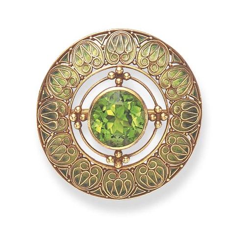 A PERIDOT AND ENAMEL BROOCH, BY LOUIS COMFORT TIFFANY, TIFFANY & CO.  Centering upon an independent circular-cut peridot, embellished by polished gold wirework and beadwork, to the openwork green plique-à-jour enameled border, mounted in gold, (with concealed pendant hoop for suspension), circa 1910 Antique Tiffany, Tiffany Art, Louis Comfort Tiffany, Peridot Jewelry, Tiffany Jewelry, Art Nouveau Jewelry, Enamel Brooch, Tiffany And Co, Gold Enamel