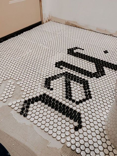 I wanted to create a unique and memorable entryway, so I wrote "HEY" in penny tile. Let me show you how to recreate this look in your own home! Drifit your penny tiles and create your art workThe most important step is to drift your penny tile and experiment with your artwork by placing the contrasting tiles right on top of the base color tiles. The individual penny's pull right off the mesh backing, making them easy to work with. For this floor, I wanted to write the word "HEY". I t… Penny Tile Stairs, Penny Tile Ideas, Black And White Penny Tile, White Penny Tile, Penny Tile Backsplash, Penny Tiles, Color Tiles, Write The Word, Bathroom Crafts