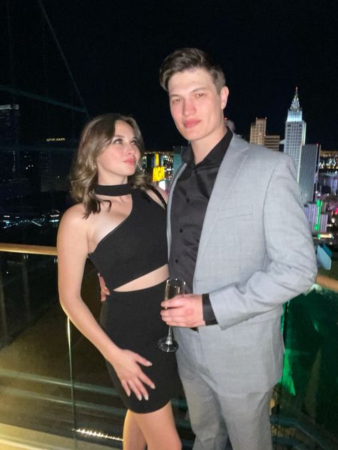 A couple pose for a night out in Vegas Black Dress Couple, Mens Grey Suit, Ceasars Palace, Dress Couple, Black Cutout Dress, Vegas Night, Couples Outfit, Dress Champagne, Grey Suit