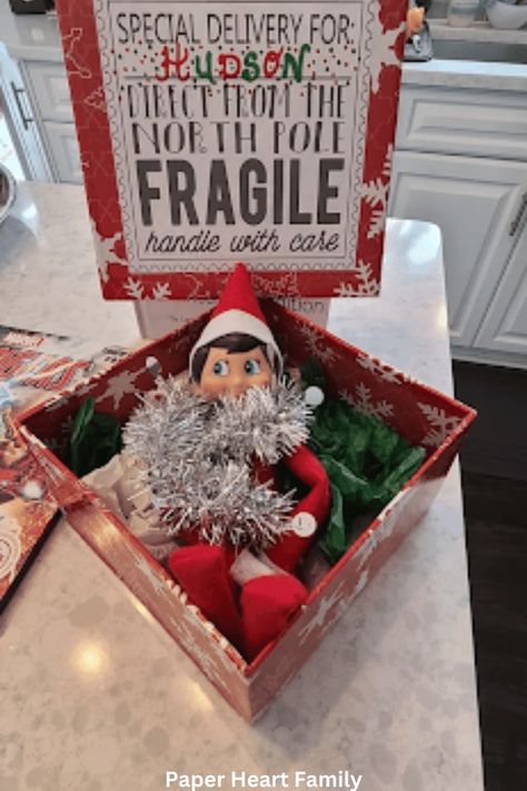 38 Fantastic Elf on the Shelf Arrival Ideas Elf In The Shelf Arrival Ideas, Elf Shelf Arrival, Elf Is Back Ideas, Napkin Folding Ideas, Fireplace Tv Wall Decor, Elf On The Shelf Arrival, Paper Napkin Folding, Elf Ideas Easy, Chirstmas Decor