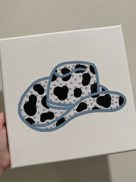 This adorable cow print cowgirl hat is now for sale! This was so FUN to make! Canvas(10x10) comes with a hook already installed on the back to make it easy to hang on the wall. Diy Cowgirl Decorations, Gem Canvas Art Easy, Fun Paintings On Canvas, Cow Diy Crafts, Cute And Easy Paintings On Canvas, Cow Canvas Painting Easy, Easy Cow Painting, Western Paintings Canvases, Gem Canvas Art