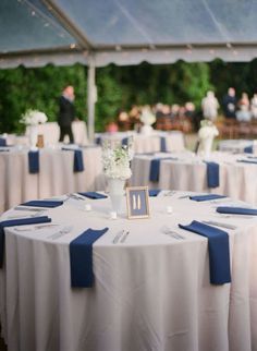 The table was decorated with a light blue tablecloth and navy blue napkins. Description from pinterest.com. I searched for this on bing.com/images White Wedding Table Decor, White Table Settings, Table Place Settings, Blue Napkins, White Table Cloth, Navy Blue Wedding, Wedding Table Settings, Charleston Wedding, Reception Table